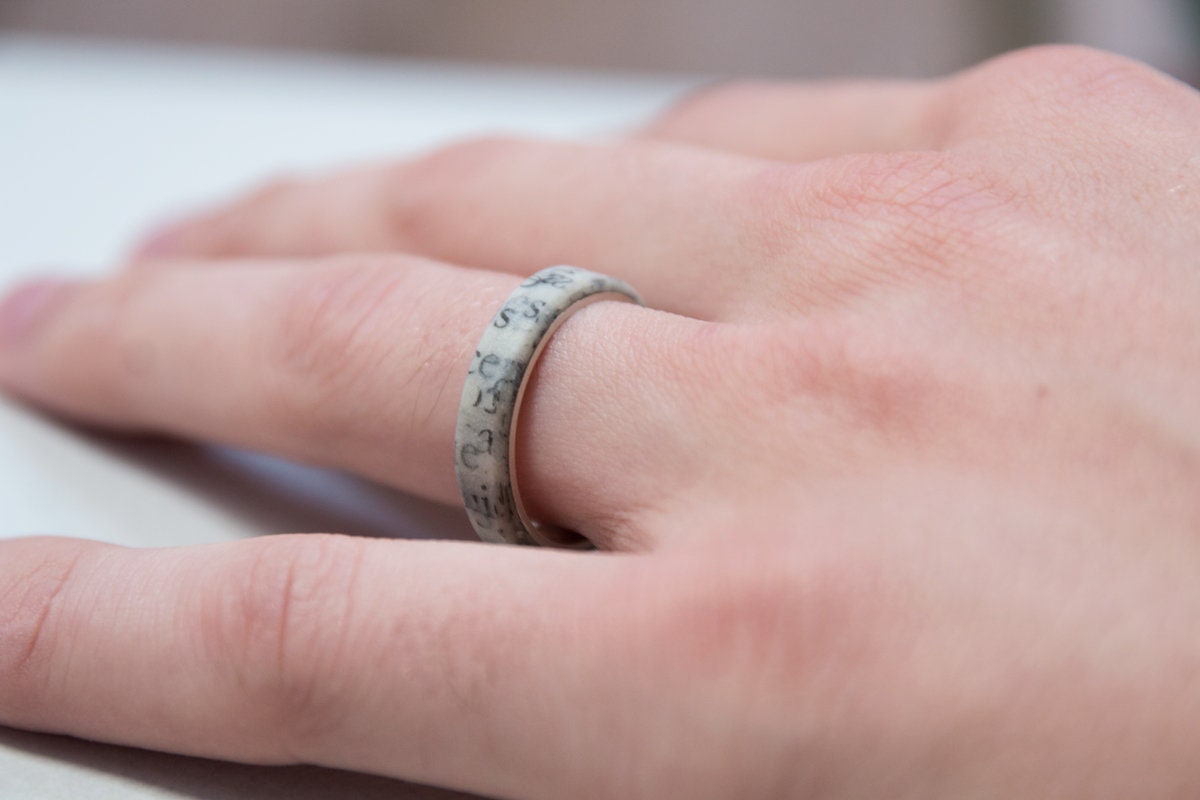 Anillo de papel con plata por dentro. Se ve desde arriba en la mano del modelo